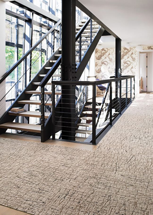 Iron staircase landing with FLOR Turkish Smoke area rug shown in Tan
